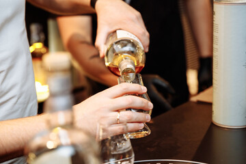 Man serving alcoholic drink into a glass