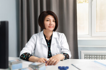 Portrait of a female doctor in an office at a table in a Kazakhstan clinic