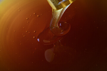 Close-up. Healthy organic Thick honey dipping from the wooden honey spoon, closeup