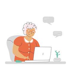 Happy granny communicates via laptop. An elderly woman is texting with relatives via a computer