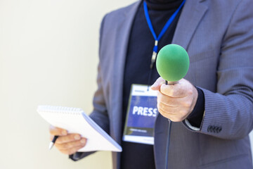 Correspondent holding microphone making media interview - obrazy, fototapety, plakaty