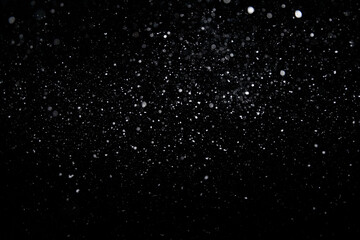 Real falling medium sized snowflakes out of focus on black background for overlay blending mode on...