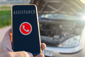 Close-up with selective focus of a phone ready to call the roadside assistance service, with a...