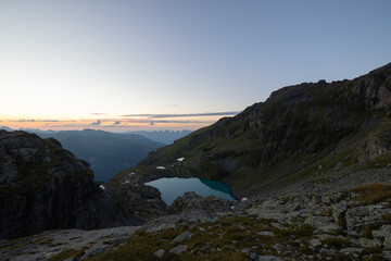 Wonderful view over a beautiful alpine lake in Switzerland called Schottensee. Epic sunrise over a perfect blue lake.