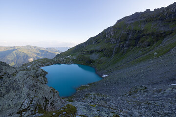 Fototapeta na wymiar Wonderful view over a beautiful alpine lake in Switzerland called Schottensee. Epic sunrise over a perfect blue lake.