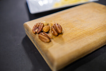 Walnuts, almonds, and Indian nuts on wooden cutting board