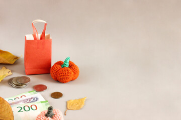 autumn sale layout on light background, shopping bag next to coins, orange yarn pumpkins and leaves, horizontal banner