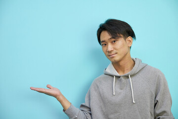 空間スペースを紹介するアジア人男性