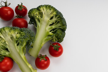 Broccoli with cherry tomatoes on a white with copy space. Healthy vegetables.