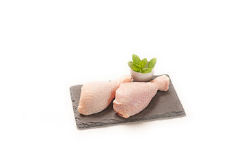 Piezas de pollo fresco crudo sobre pizarra plato aislado en fondo blanco