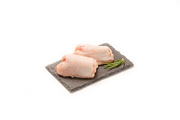 Piezas de pollo fresco crudo sobre pizarra plato aislado en fondo blanco