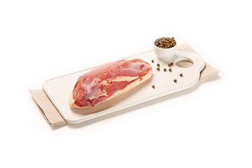 magret de pato fresco crudo en plato blanco con servilleta beige y pimienta negra aislado fondo blanco