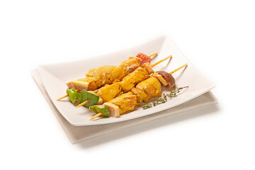 pinchos morunos de cerdo pollo adobado fresco crudo sobre plato blanco con servilleta de tela gris, aislado fondo blanco