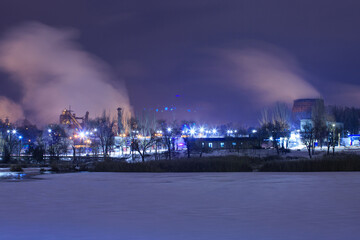 Nighttime winter snow scenery of the blast furnace of the iron and steel works shot on a long exposure 