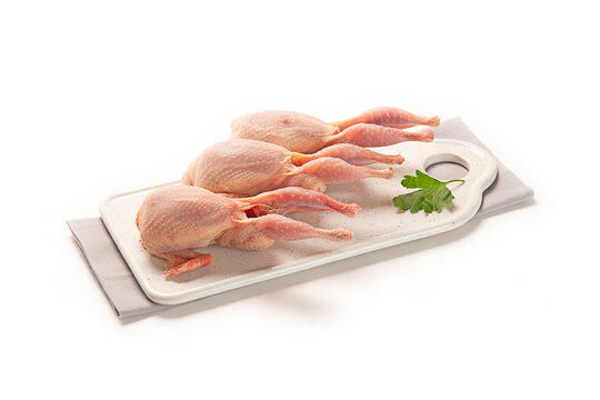 codorniz fresca cruda en una bandeja blanca con servilleta de tela, aislada fondo blanco
