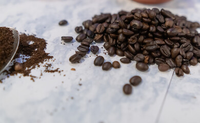 Small pile of roasted coffee beans on white surface