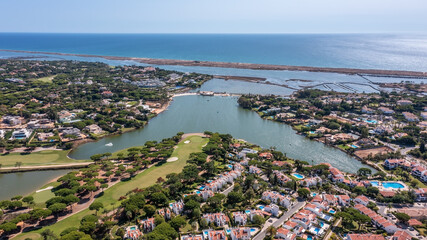 Fototapeta na wymiar Aerial overview of luxury villas located around Quinta do Lago, Algarve, Portugal, Europe. Drone shot in the green zone.