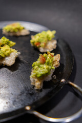 Pork rinds with guacamole on traditional Mexican comal