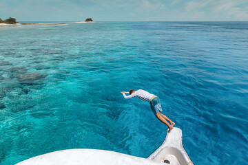 Young man jumping from a boat