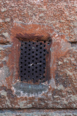 Old brick wall with a metal object in it
