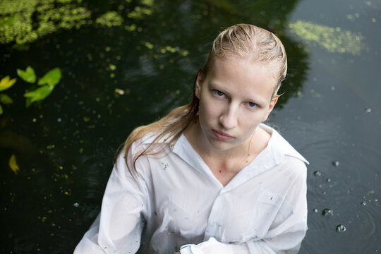 Young adolescent girl swim in the pond with algae