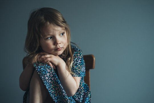 Little cute girl sitting on the chair.
