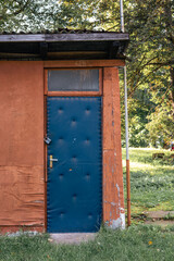 Blue door with texture on an orange wall in Eastern Europe