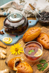 tea party concept with sweet cakes on wooden table, glass cup and teapot, selective focus

