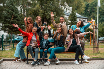 Portrait photo of a group of young people having fun while sitting in a park. Selective focus