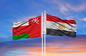 Oman and Egypt two flags on flagpoles and blue sky