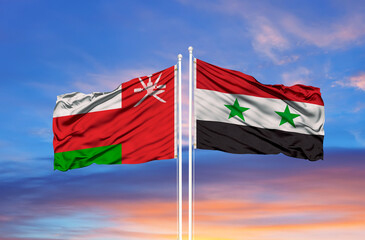 Oman and Syria flag waving in the wind against white cloudy blue sky together. Diplomacy concept, international relations