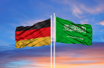 Saudi Arabia and Germany two flags on flagpoles and blue cloudy sky