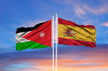 Jordan and Spain two flags on flagpoles and blue cloudy sky