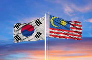 South Korea and Malaysia two flags on flagpoles and blue cloudy sky