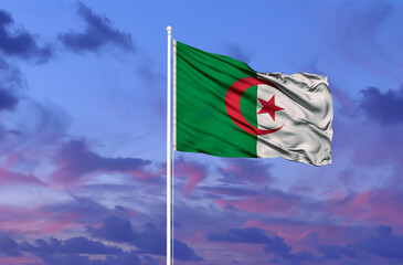 Algeria flag waving against a clean blue sky, close up, independence day concept