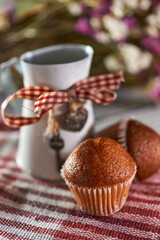 Miniature metal milk jug with tiny cakes on a rustic background