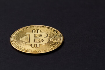The concept of the bitcoin cryptocurrency financial market. The bitcoin logo on a dark background. Gold coin of bitcoin macro photography. The bitcoin is the coin of the future. Free space