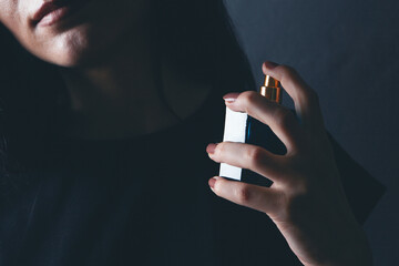 woman sprinkles perfume on her neck