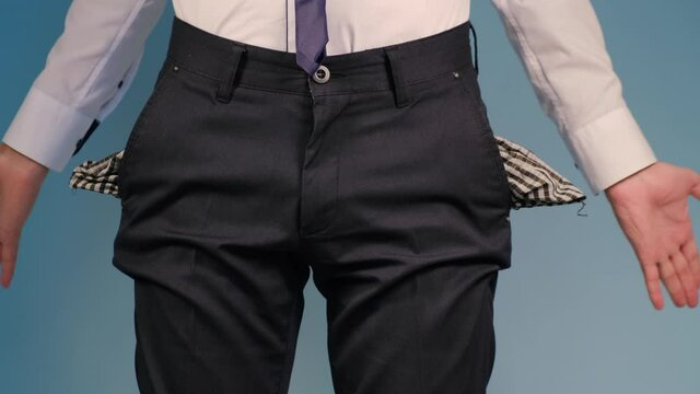 A man turns empty pockets of his trousers