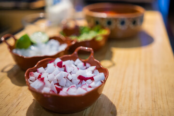 Obraz na płótnie Canvas Clay bowls of chopped radishes and onions, and delicious Mexican pozole