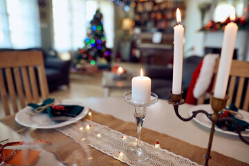 White lighted candle on dining table on Christmas.