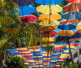 Multicolored umbrellas hanging at the top of a commercial street in Cyprus