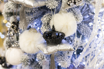 Close up of holidays location with fluffy toys, garlands and black crown on Christmas tree