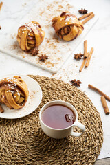 Fresh vegan cinnamon buns on marble board and white marble table