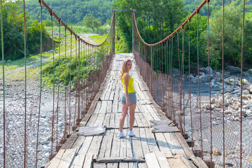 a woman stands on a suspension bridge in Georgia