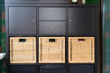 Wicker boxes for things on the shelves. Wardrobe for storage of things. High quality photo