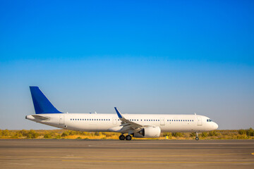 The plane is preparing to fly at the airport. Airplane on the runway at the airport. The turbine of the aircraft is warming up, the landing gear is preparing for flight. The plane flies in the sky.