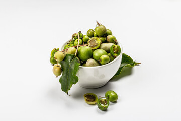 Ripe Actinidia arguta or kiwi in a bowl isolated on white background