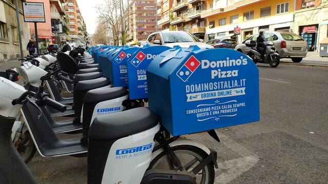 Rome, 17 March 2021: electric scooters for the deliveries of the DOMINO'S PIZZA pizzeria chain. Founded in 1960 by brothers Tom and James Monaghan in Michigan, present in 70 countries around the world
