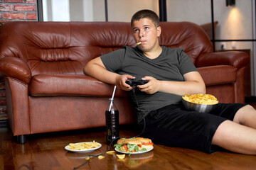 caucasian child boy eating fries. Fast food. Kid and unhealthy lifestyle concept. teenager boy...
